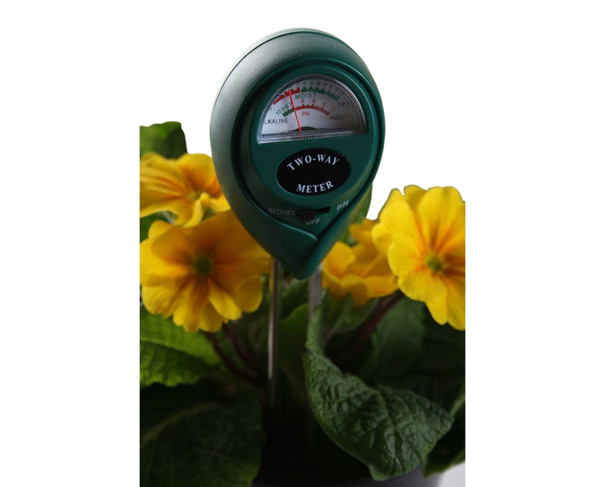 Active Air 2-Way Moisture and pH Meter inserted in soil among yellow flowers for real-time testing.