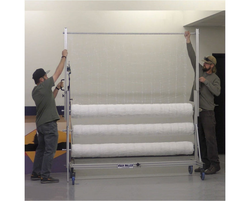Two workers setting up EZ Trim High Roller with trellis netting stretched across three rollers for large-scale plant support.