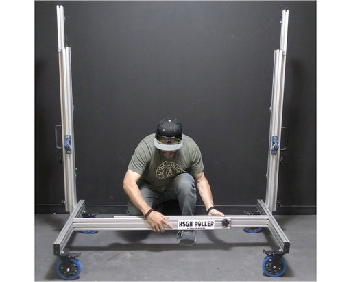 Worker adjusting EZ Trim High Roller base, showcasing easy width customization with labeled frame and locking casters.