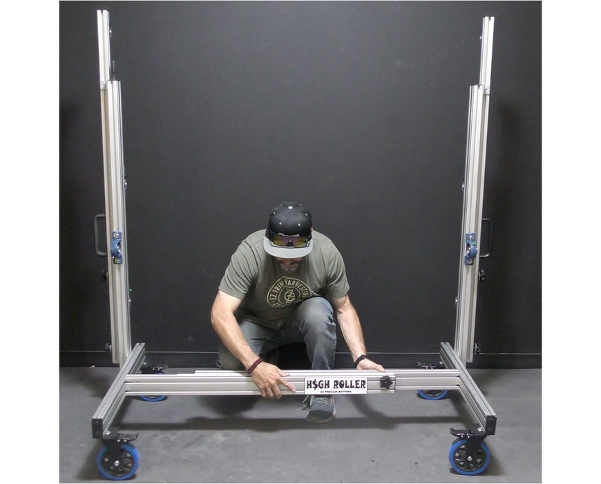 Worker adjusting EZ Trim High Roller base, showcasing easy width customization with labeled frame and locking casters.