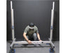 Worker adjusting EZ Trim High Roller base, showcasing easy width customization with labeled frame and locking casters.