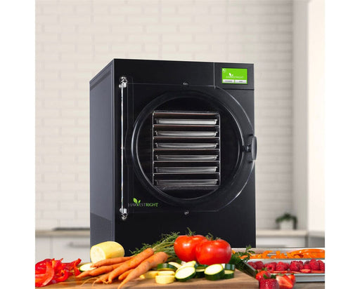 Black Harvest Right Home Pro Freeze Dryer with vegetables on a wooden surface.