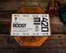 Integra BOOST 420g 69% RH humidity control pack on a wooden tray beside a drink, highlighting storage use context.