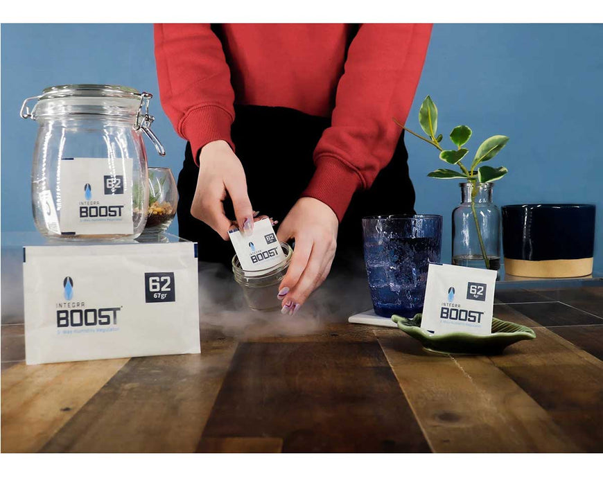 BOOST 67g 62% RH humidity control pack being placed in jar, shown in real-use setting.