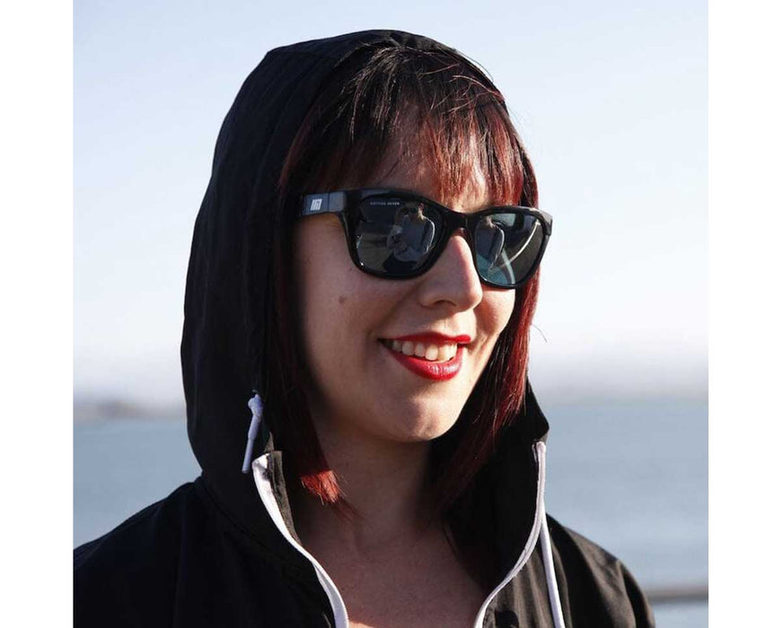 Woman smiling outdoors wearing Method Seven Coup HPS sunglasses with reflective lenses.