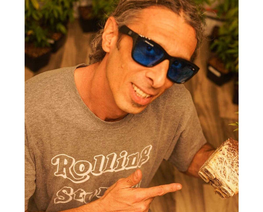 Grower indoors wearing Method Seven Coup HPS glasses while holding a plant root ball.