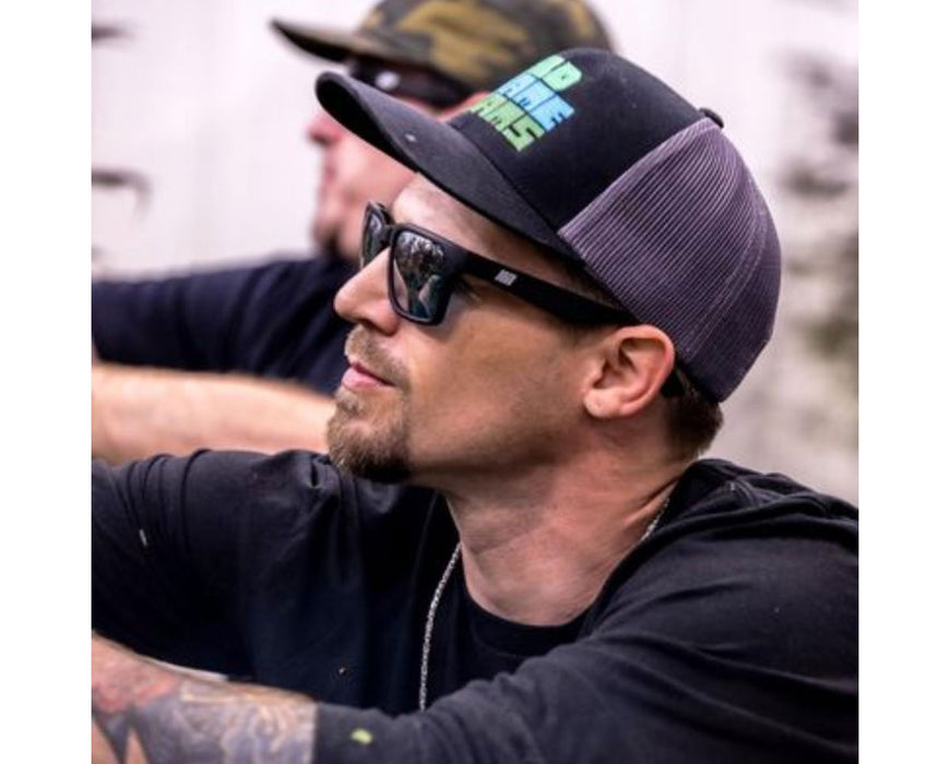 Man in black shirt and cap wearing Method Seven Evolution HPS+ glasses during cultivation work indoors.