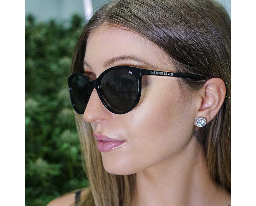 Woman wearing Method Seven Lennox Sun Polarized sunglasses, highlighting the frame's sleek design and brand name.