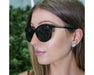Woman wearing Method Seven Lennox Sun Polarized sunglasses, highlighting the frame's sleek design and brand name.