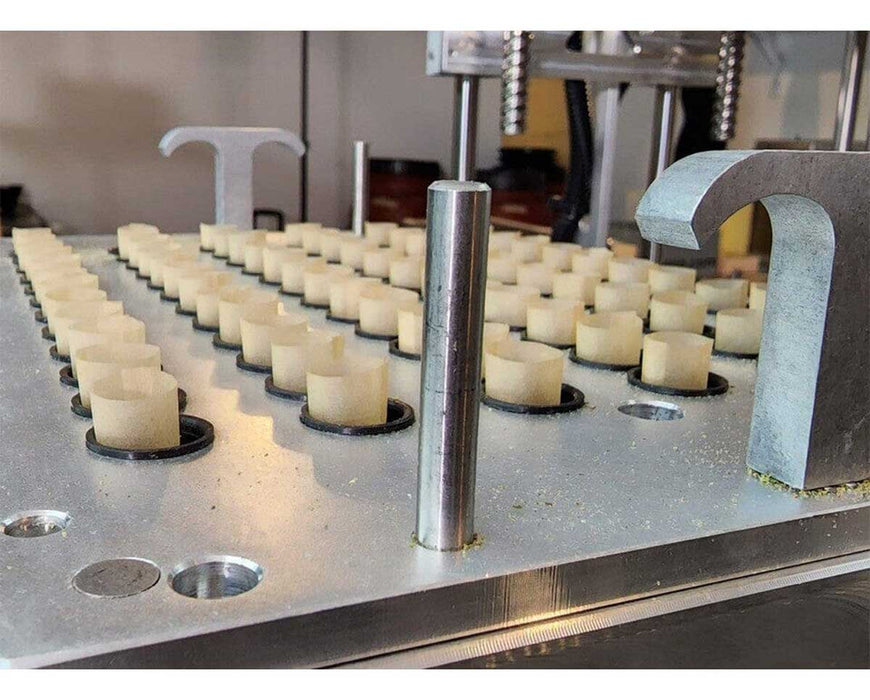 Close-up of filled pre-roll cones arranged in the STM Atomic Closer plate before sealing