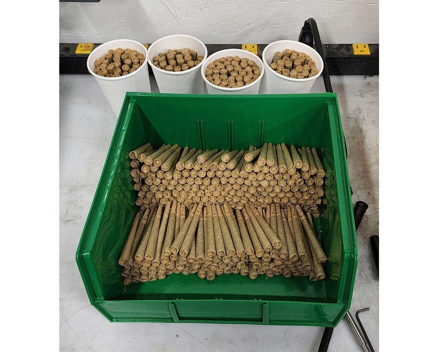 Green plastic bin filled with tightly packed finished pre-rolls ready for packaging