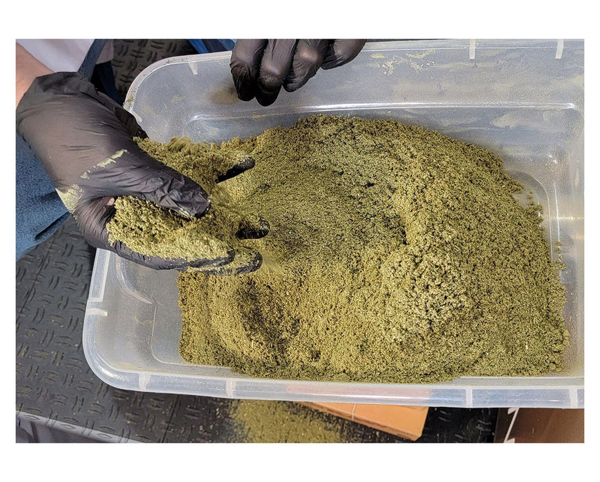 Close-up of ground bud output from STM Revolution 2.0, held in gloved hands for inspection.