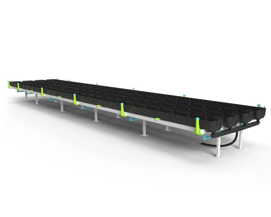 Angled side view of a full Botanicare Slide Bench setup showing long rows of black grow trays supported by a modular steel frame with green and blue hardware. The setup demonstrates scalability and durability.