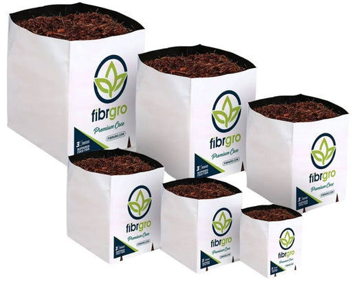 Lineup of six Fibrgro Premium Coco grow bags in varying sizes, all filled with a 40% coir chip and 60% fine coco pith mix and wrapped in white sleeves printed with Fibrgro branding.
