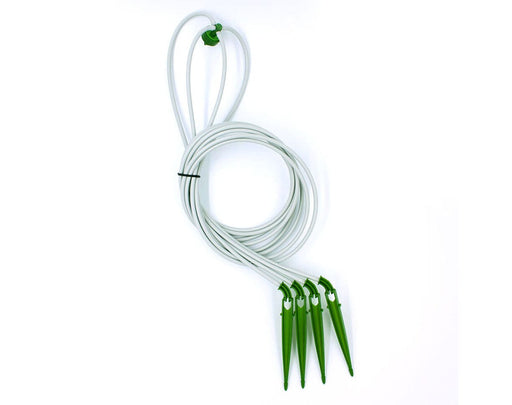 Coiled FloraFlex 4-Way Assembly showing green emitter and four connected tubing lines with drippers.