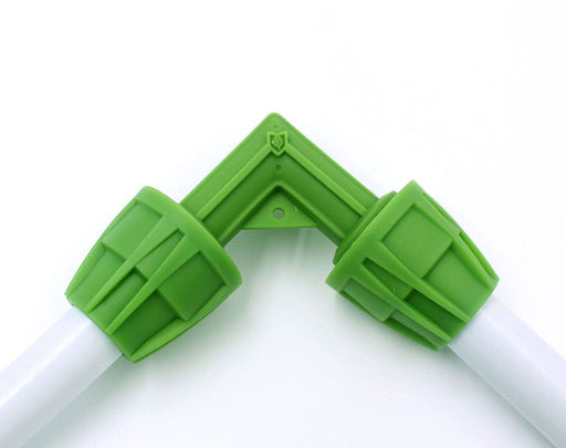 FloraFlex elbow fitting in use, joining two pieces of 16-17mm double-layer tubing with tight seal.