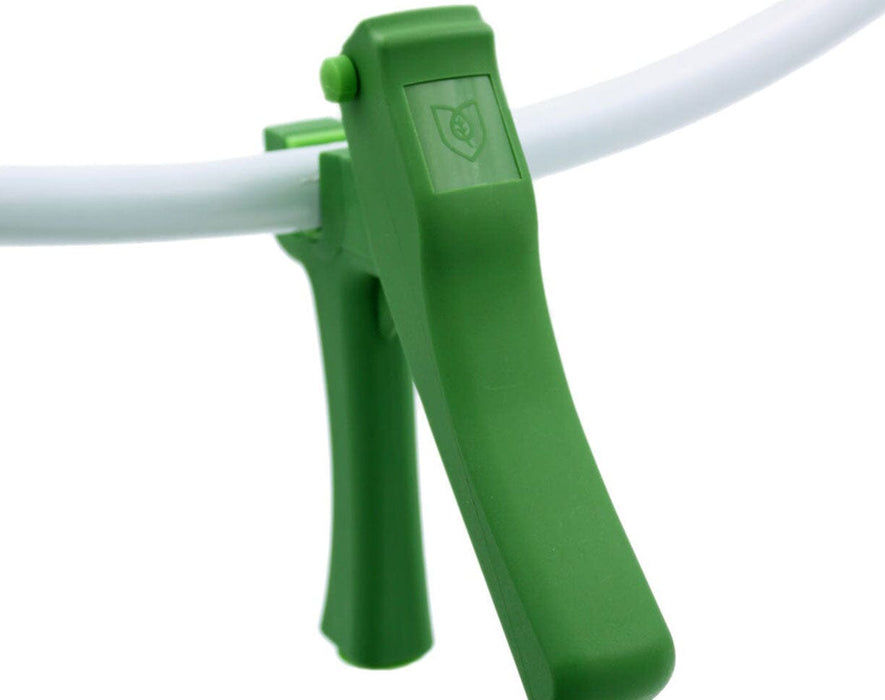 Flora Puncher in use punching a hole in white poly irrigation tubing.