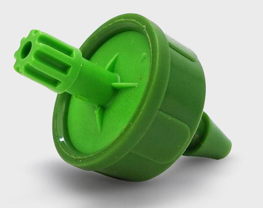 Angled close-up of green FloraFlex micro emitter showing inlet barb and drip outlet.