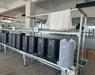 Production line with multiple Mammoth Clean Air 2nd Gen Air Sanitizers undergoing assembly and testing in a factory setting.