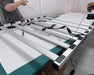 Technicians assemble Nova Sun Series LED grow light, attaching suspension wires for overhead installation in grow space.