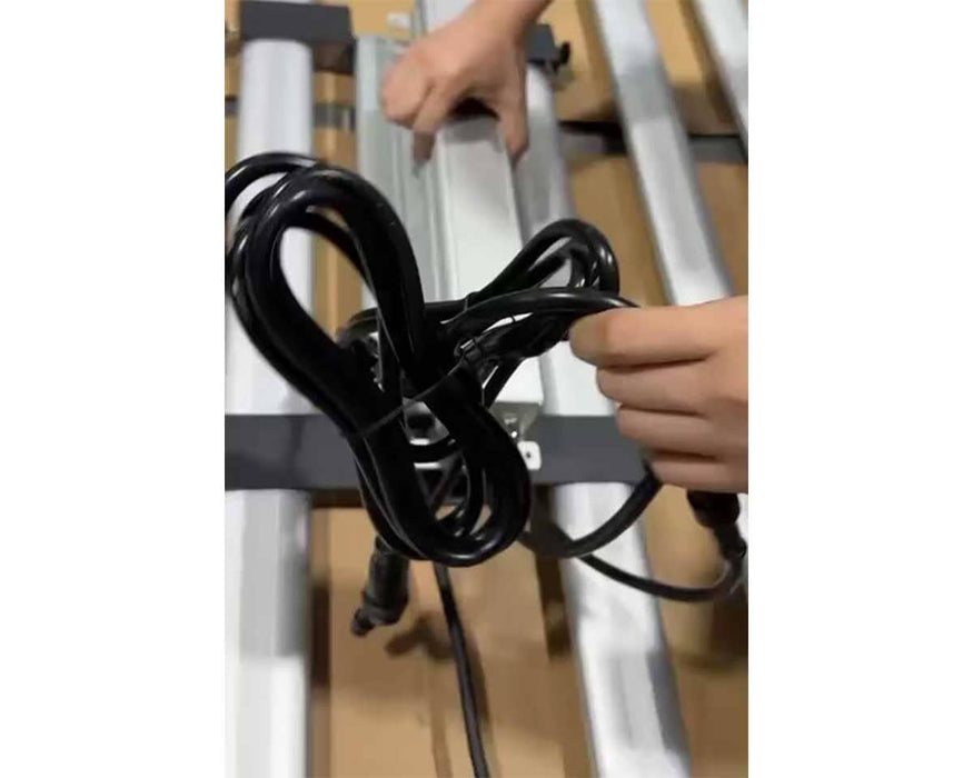 Grower installing Mammoth UV bar onto existing light fixture, holding power cable for connection.