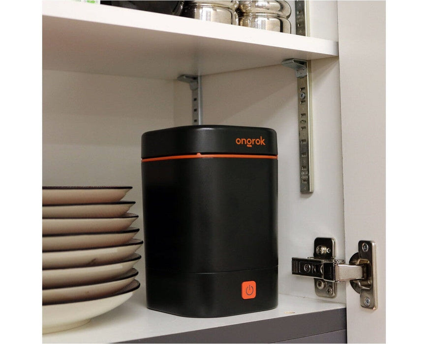 Ongrok Decarboxylator Machine stored neatly in a kitchen cupboard beside plates, showing its compact footprint and discreet storage capability.