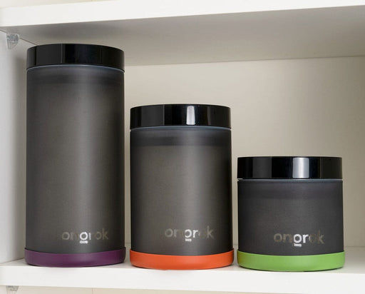 Three ONGROK frosted glass jars of varying sizes displayed side-by-side on a shelf, each with a different colored silicone base for easy identification.