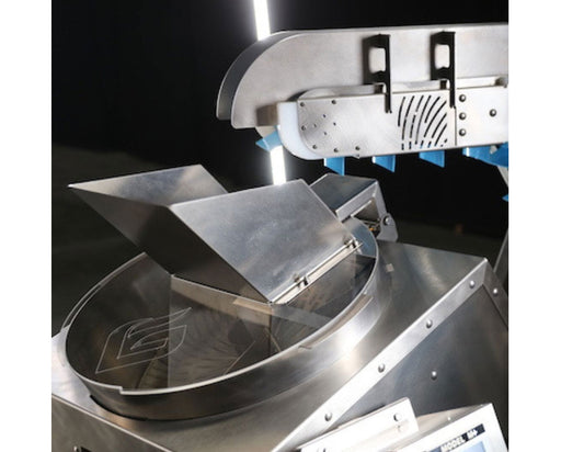 Close-up of GreenBroz M+ Trimming System feed chute and conveyor belt showing stainless steel construction and belt paddles.