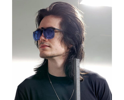 Man wearing Method Seven HPS clip-on lenses over prescription glasses in a bright indoor setting.