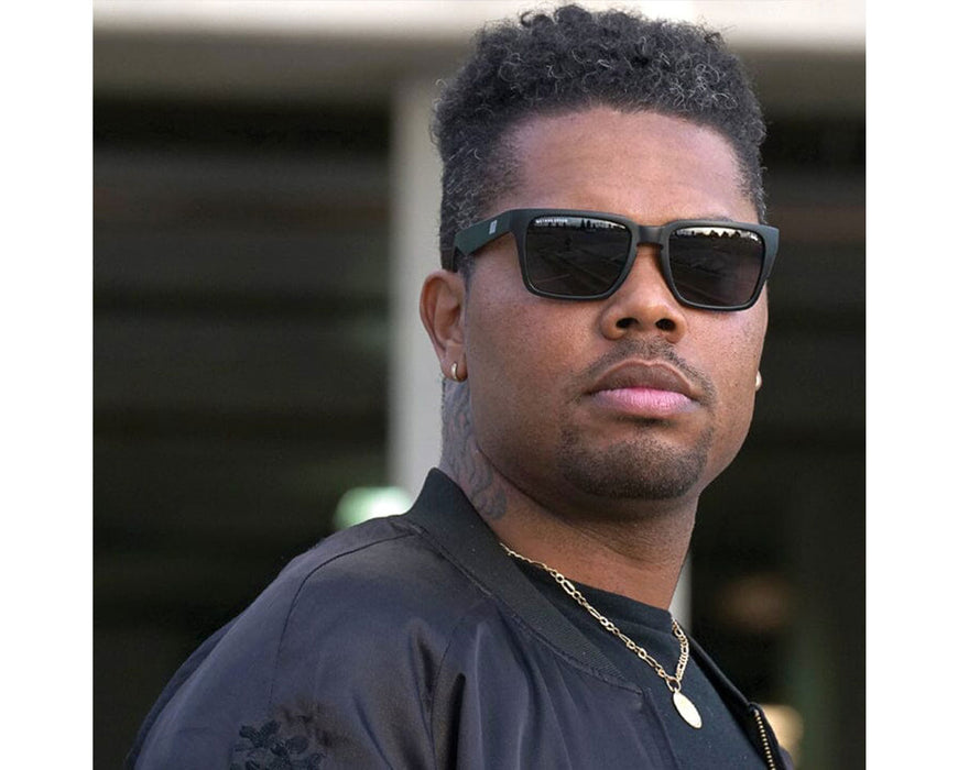 Man in a black jacket and gold chain wearing Method Seven Evolution SUN Polarized sunglasses, looking confidently at the camera.