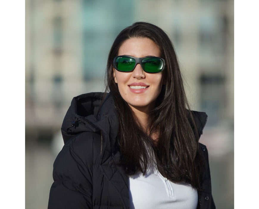 Smiling woman outdoors wearing Method Seven Operator LED glasses with green lenses and black frame.