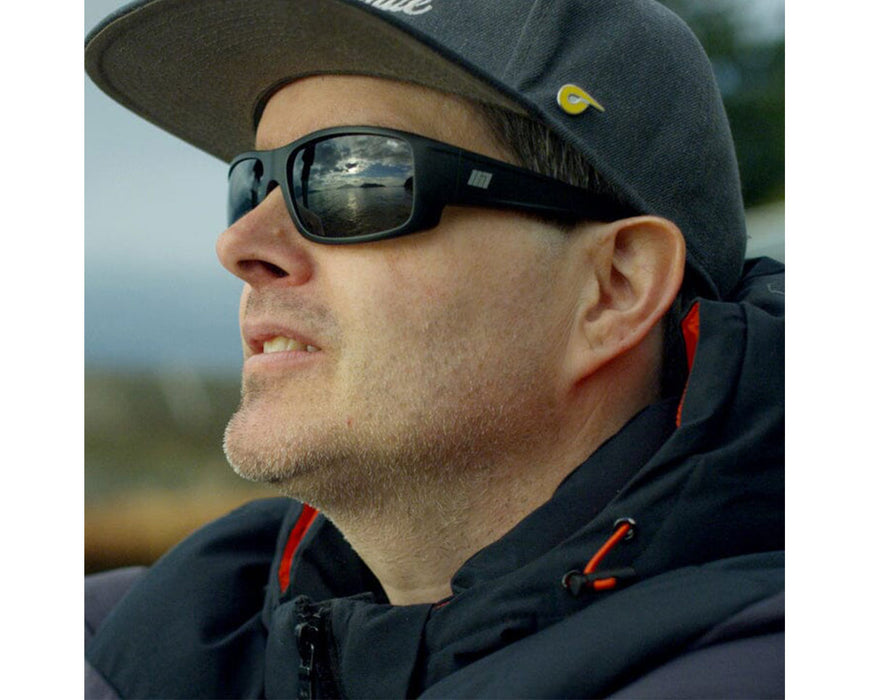 Man outdoors wearing Method Seven Resistance 2 Sun Polarized glasses, showing reflective lenses and durable frame.