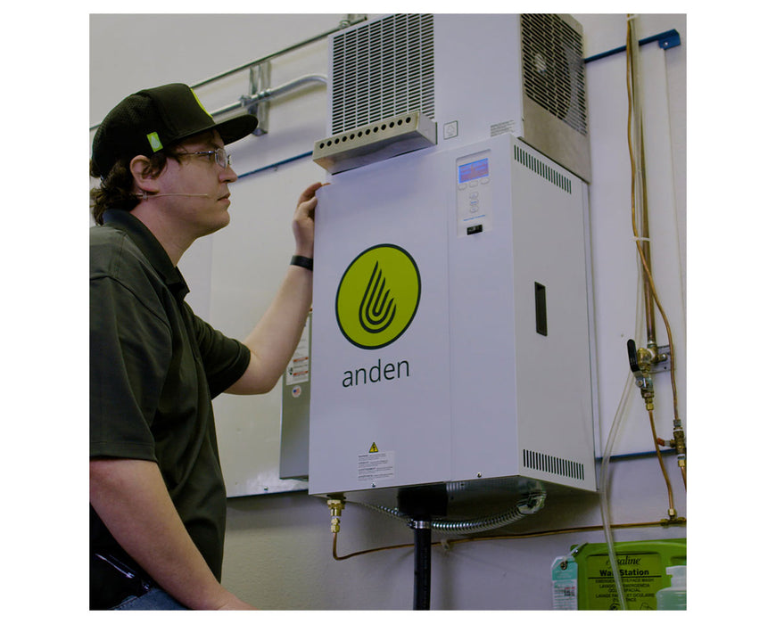 Technician adjusting Anden AS150 steam humidifier mounted on wall in indoor cultivation facility.